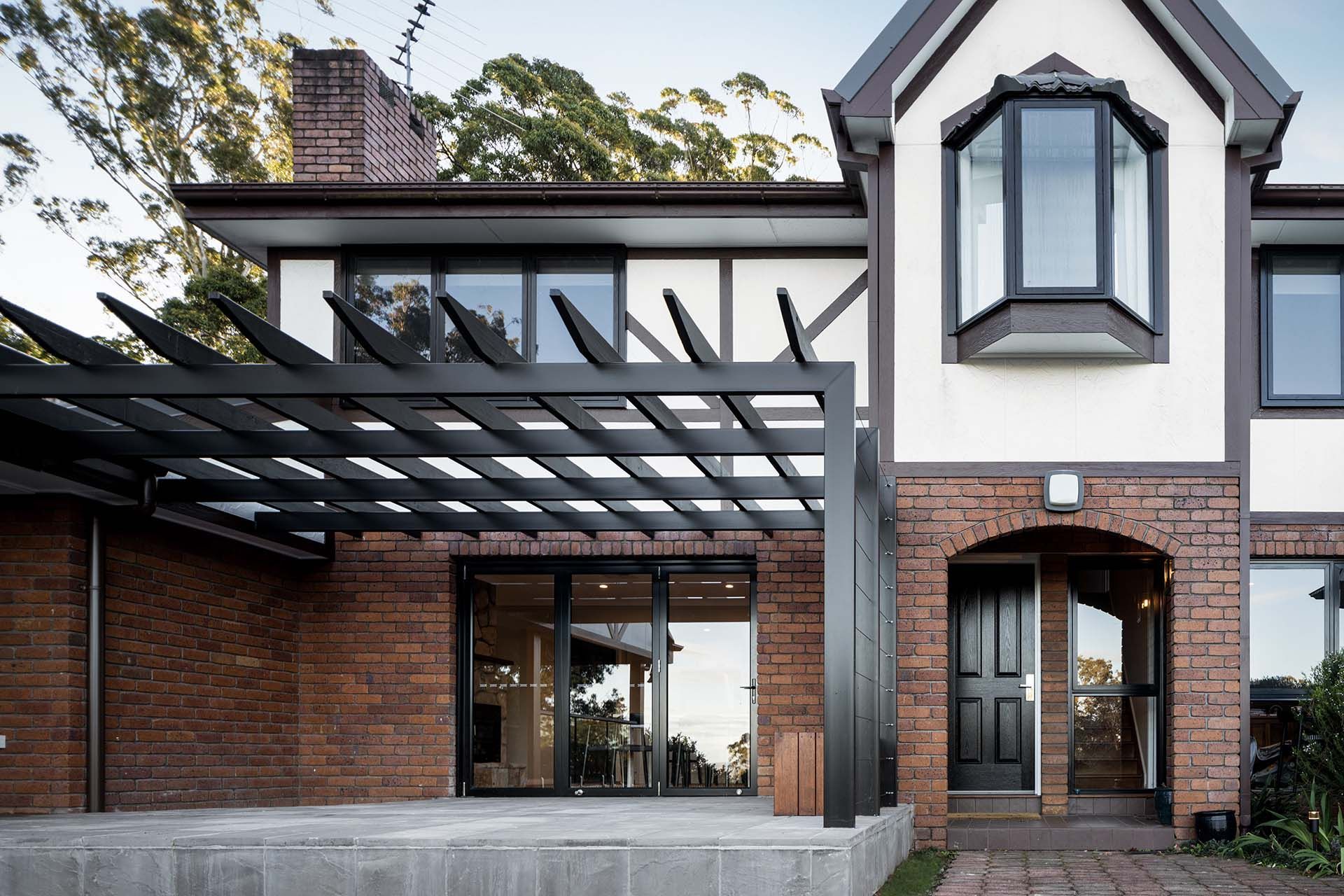 a large brick house with a pergola in front of it