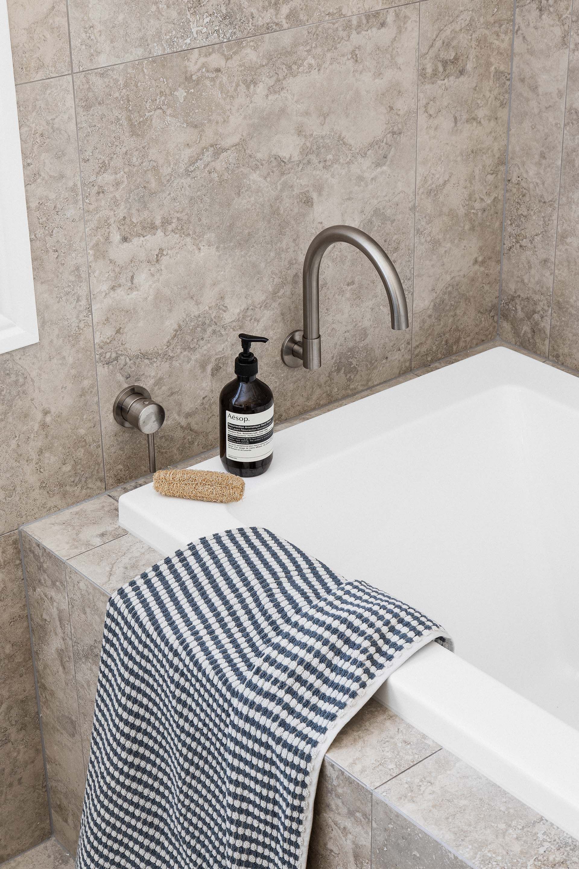 a bathtub with a towel and a soap dispenser on it .