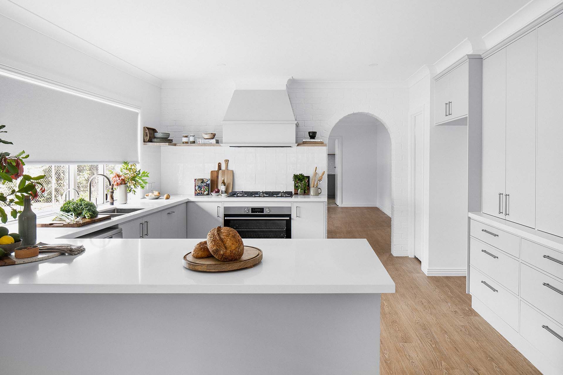 a kitchen with white cabinets and a white counter top .