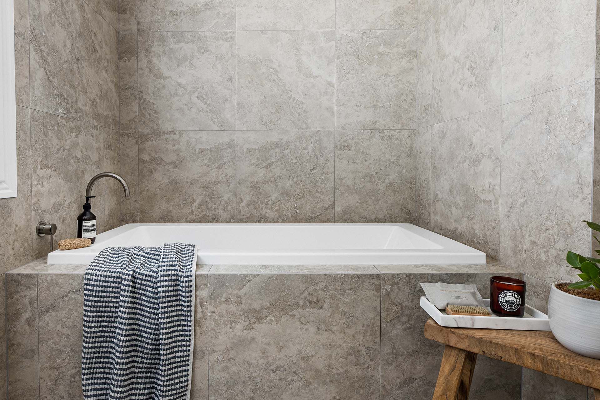 a bathroom with a bathtub and a wooden bench .