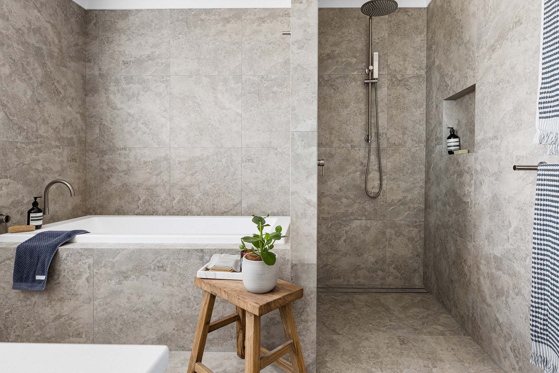 a bathroom with a tub , shower , and stool .