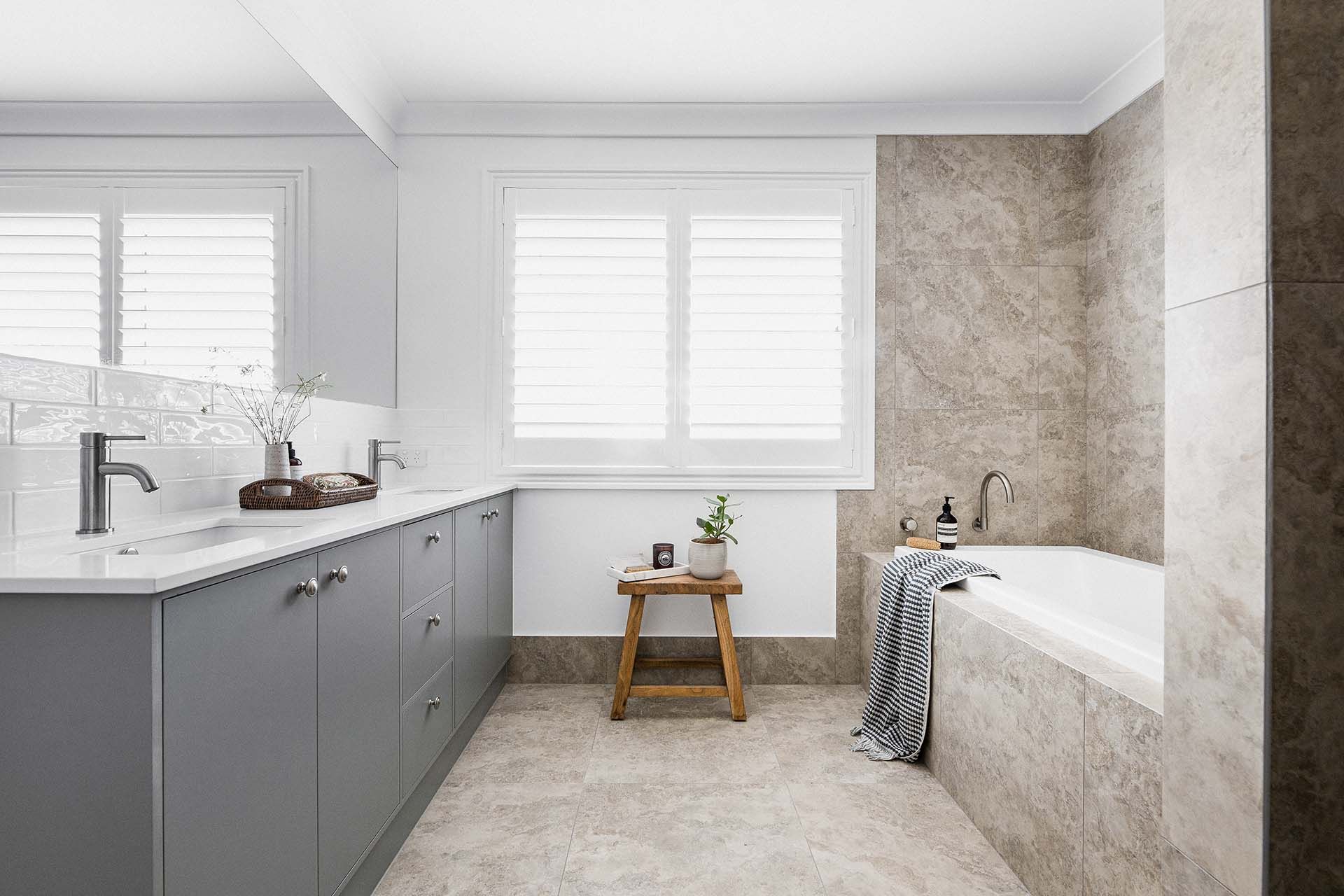 a bathroom with a tub , sink , and window .