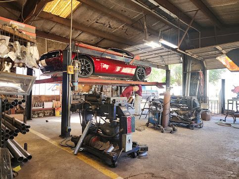 A red sports car is parked on a lift in a garage.