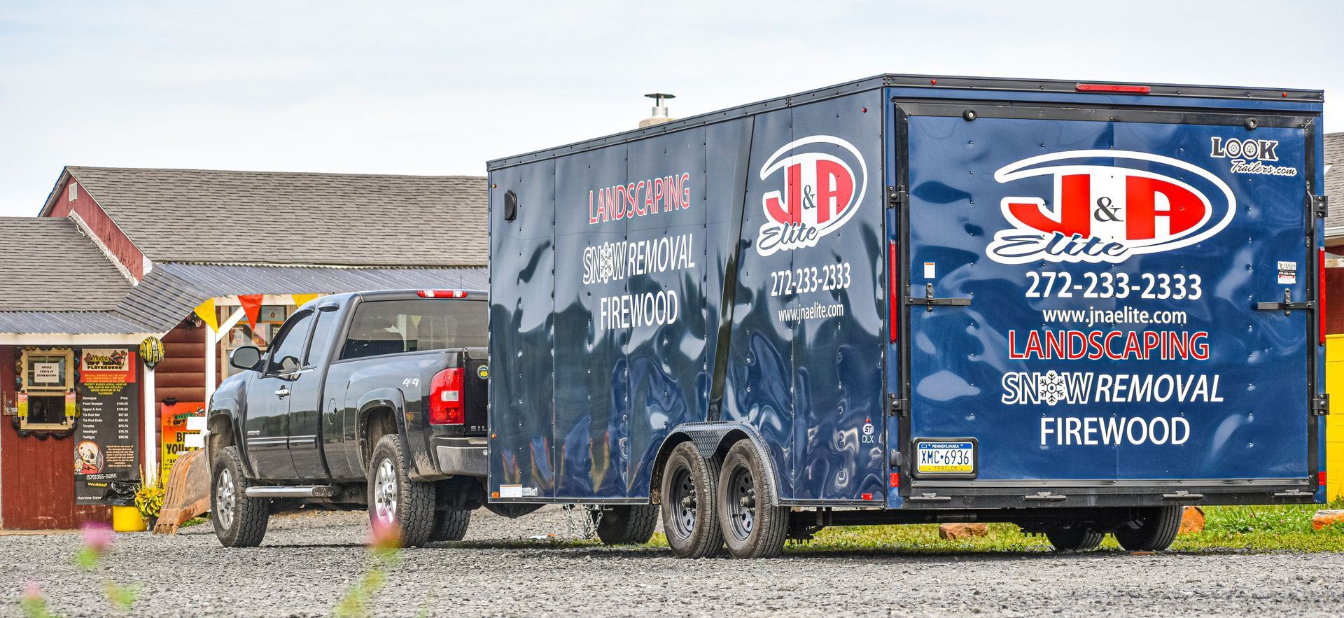A truck and trailer are parked in front of a house.