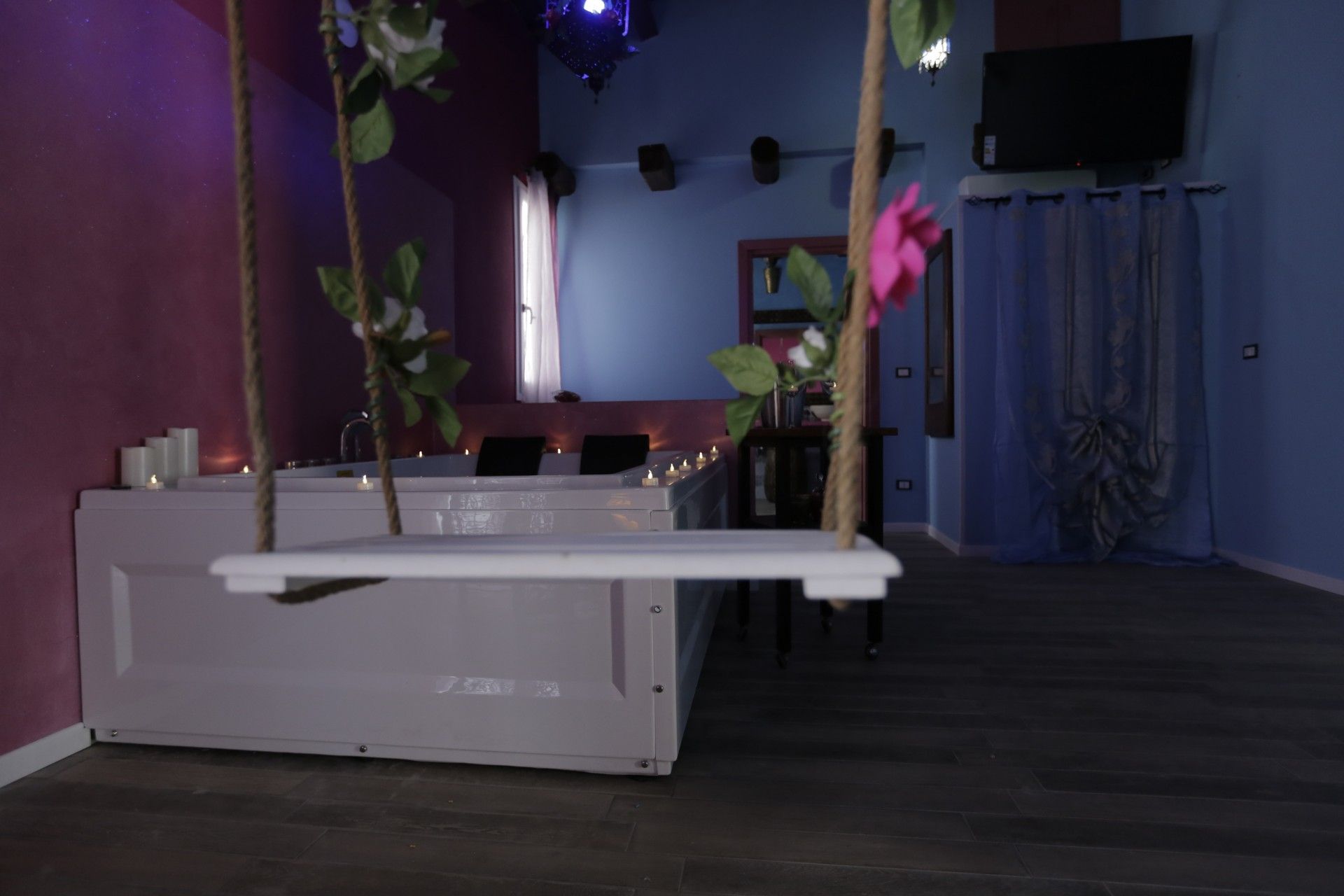 Una stanza con una vasca idromassaggio e un'altalena appesa al soffitto.