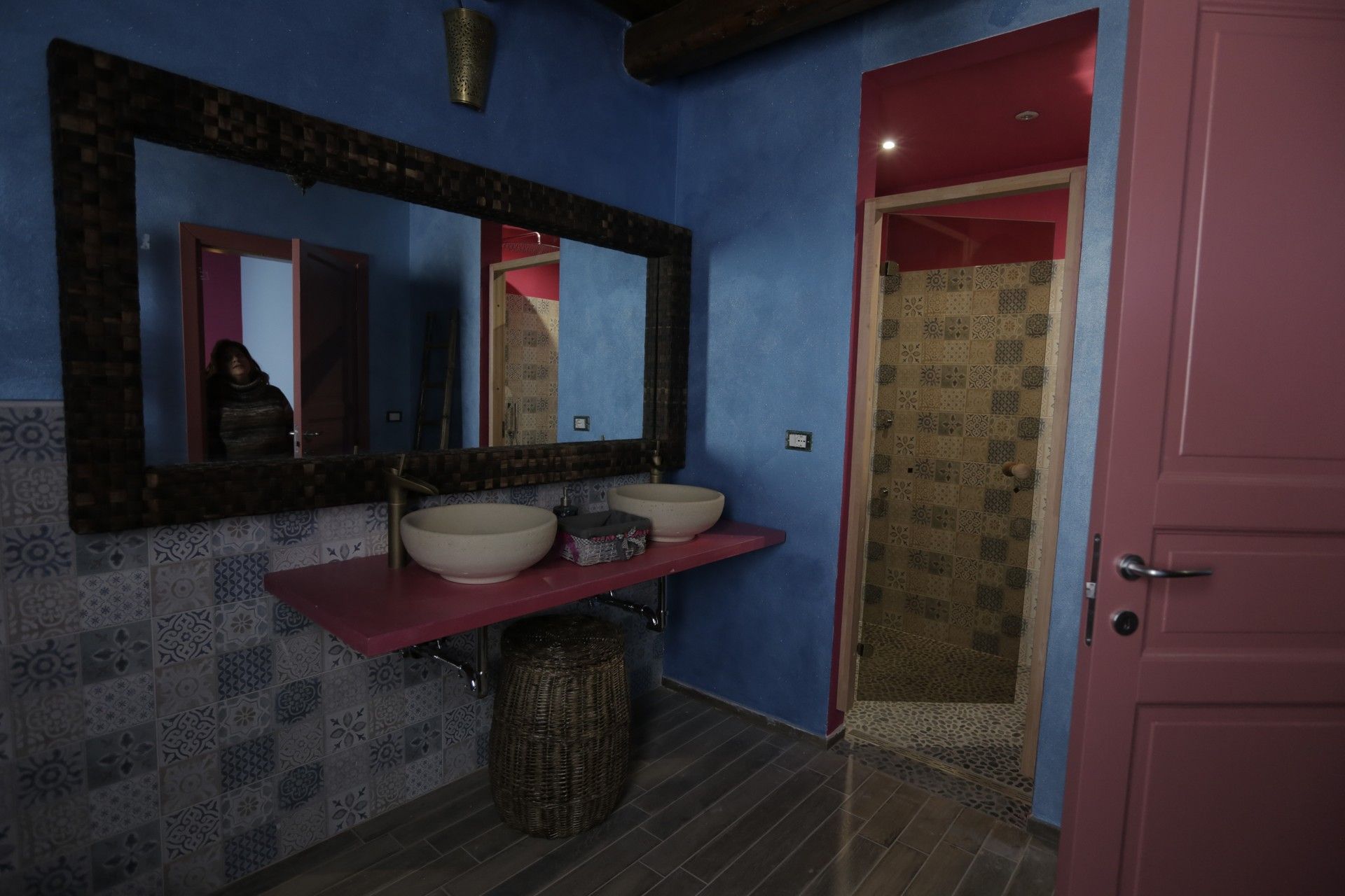 Un bagno con due lavandini, due specchi e una porta rosa