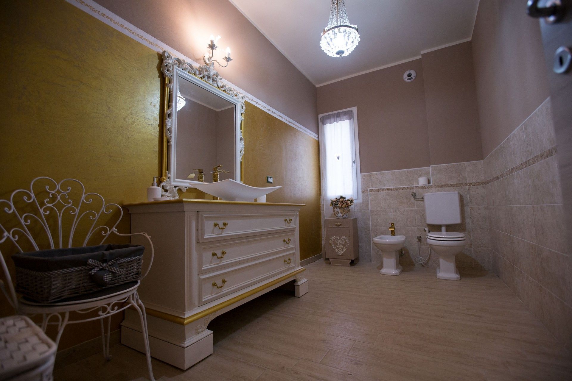 Un bagno con lavandino, water, bidet e specchio.