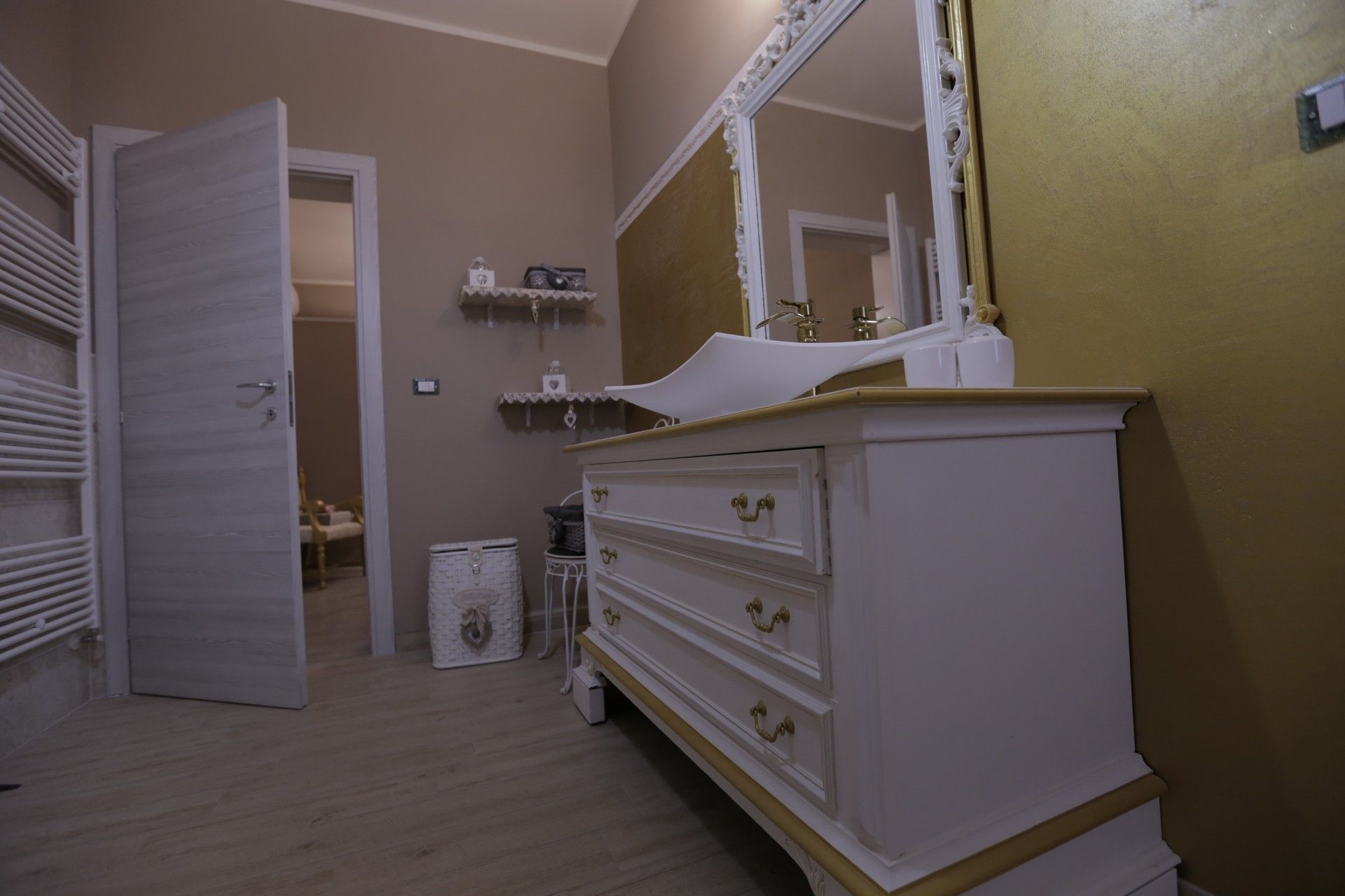 Un bagno con una cassettiera, un lavandino e uno specchio