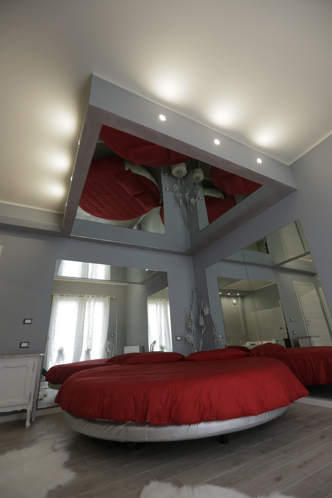 Una camera da letto con un letto rotondo e un soffitto a specchio