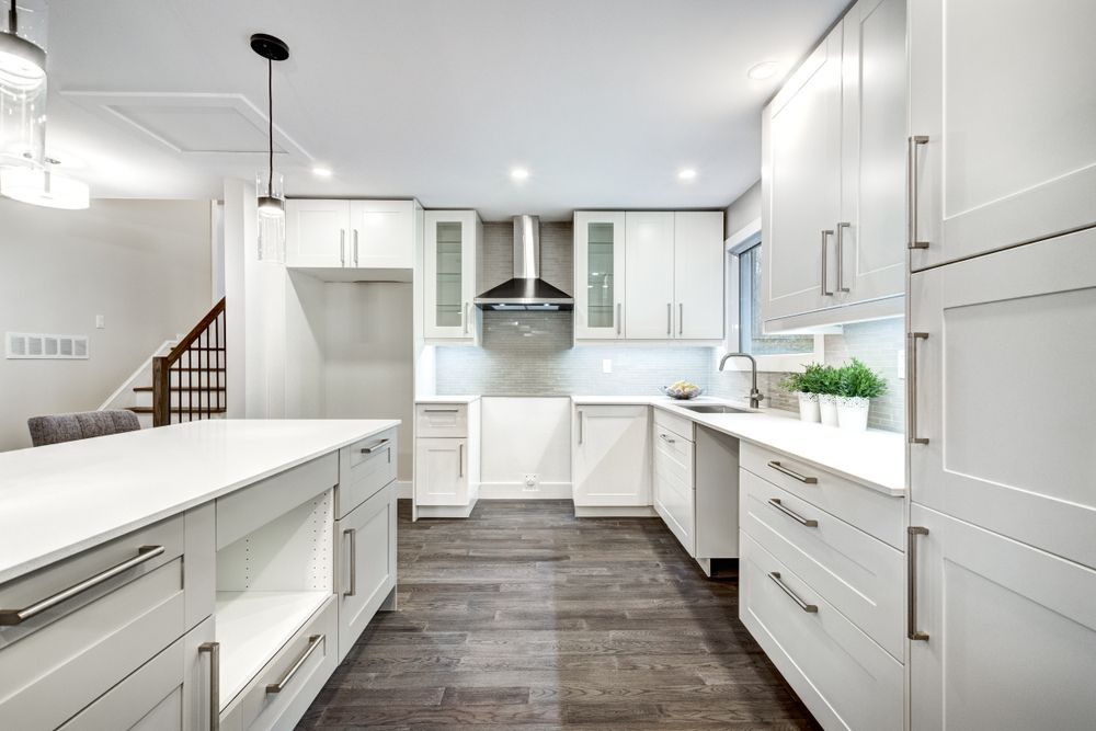 A Kitchen With a Large Island, Rangehood and White Cupboards— PKJ Designs in Unanderra, NSW