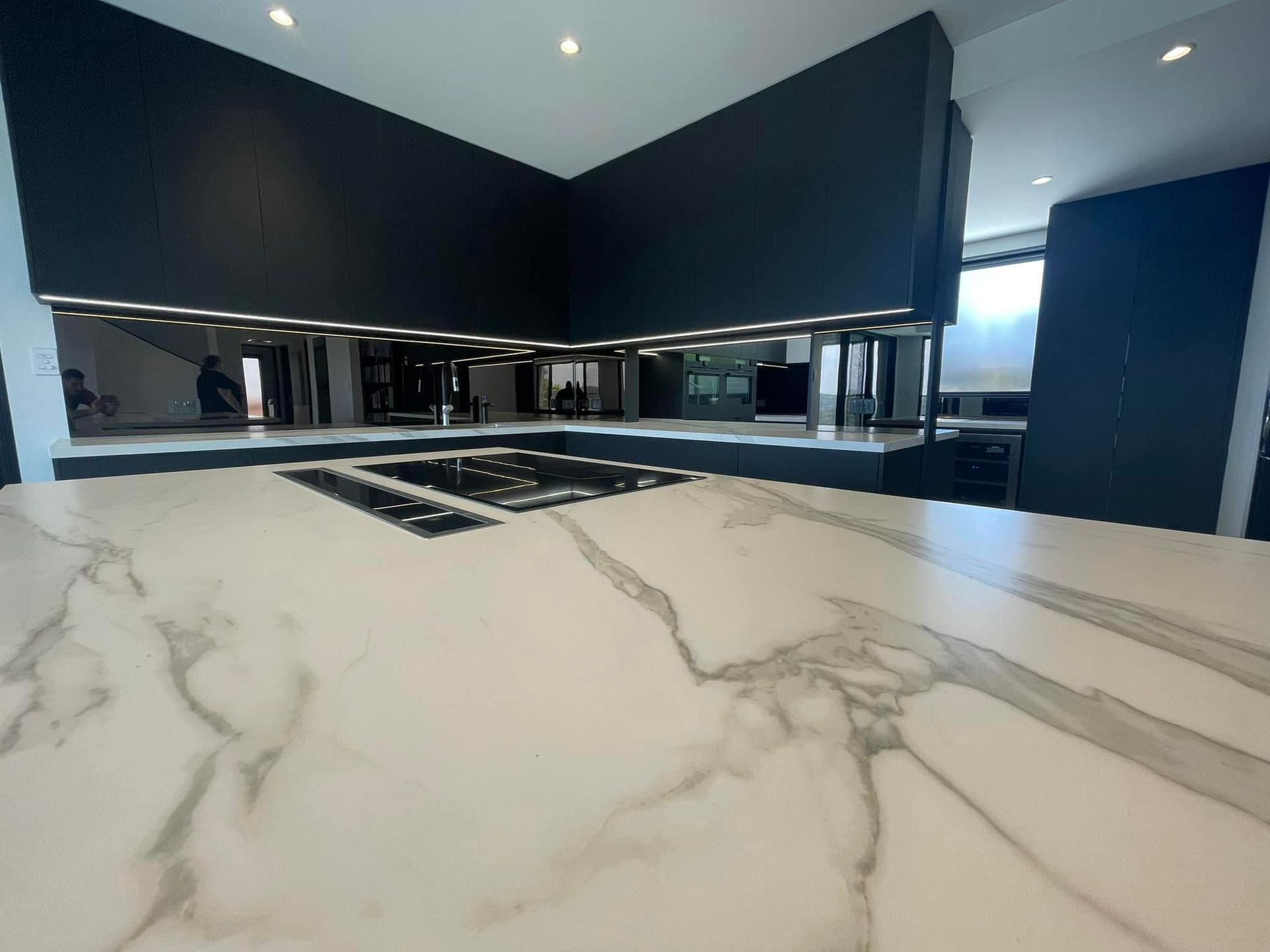 A Kitchen With a Marble Counter Top and Black Cabinets — PKJ Designs in Unanderra, NSW