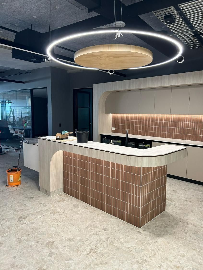 A Kitchen With a Large Island and a Circular Light Hanging From the Ceiling — PKJ Designs in Unanderra, NSW