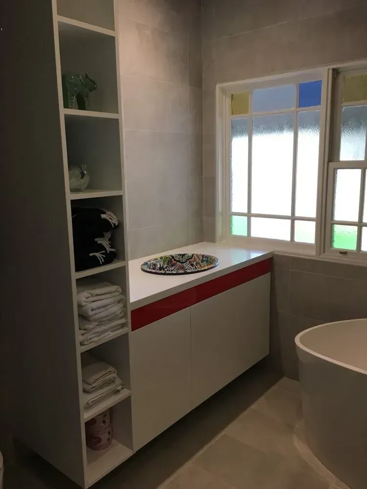 A Bathroom Vanity With Shelves With Towels And A Bathtub — PKJ Designs in Unanderra, NSW