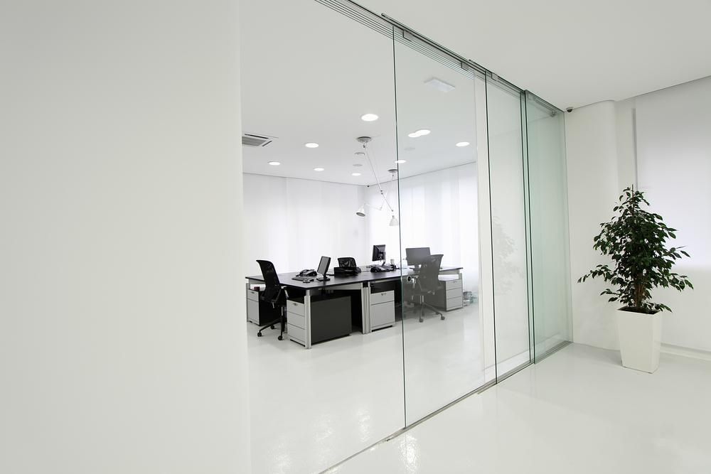 A Modern Office With Sliding Glass Doors and Cubicles — PKJ Designs in Unanderra, NSW
