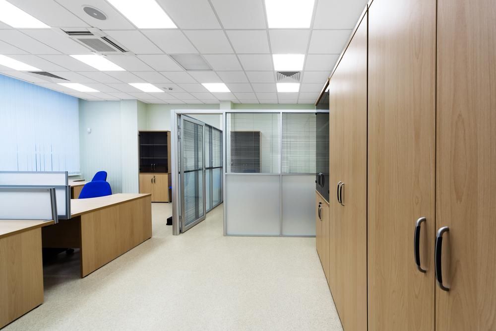 An Empty Office With Wooden Desks and Cabinets — PKJ Designs in Unanderra, NSW