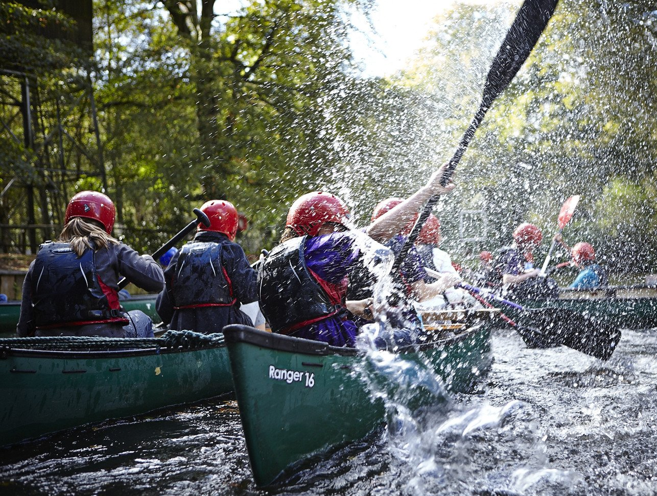 Explorer Scouts canoeing down a river