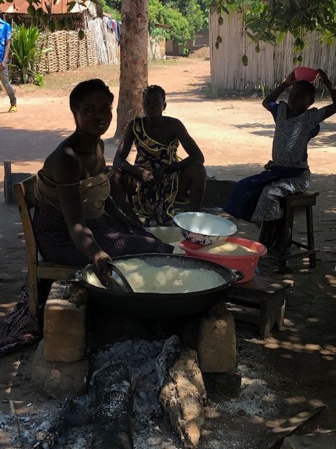 A group of people are sitting around a table cooking food.
