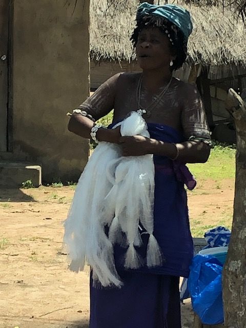 A woman in a blue dress is holding a white cloth