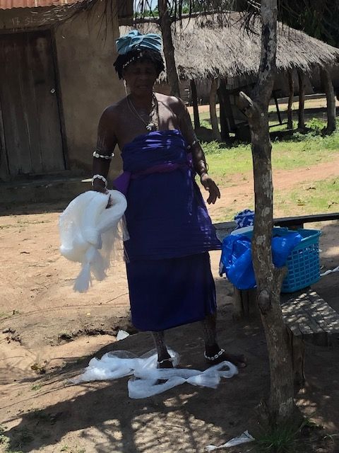 A woman in a purple dress is holding a white cloth