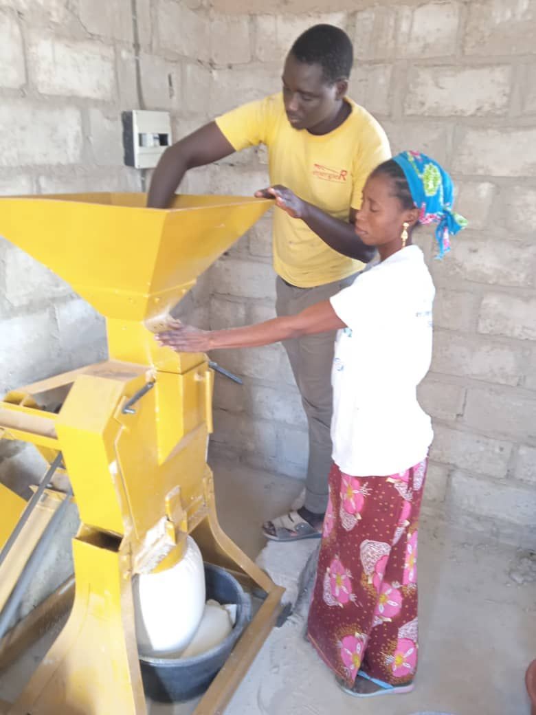 A man and a woman are working on a yellow machine