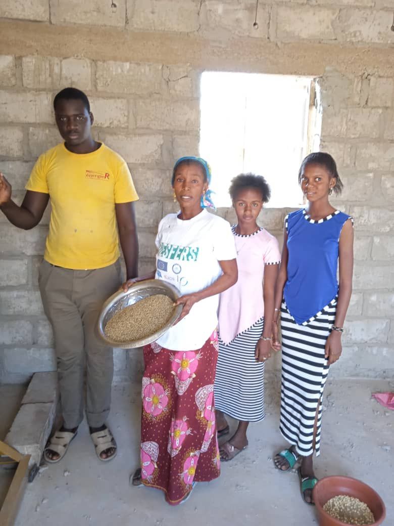 A man in a yellow shirt is standing next to two girls