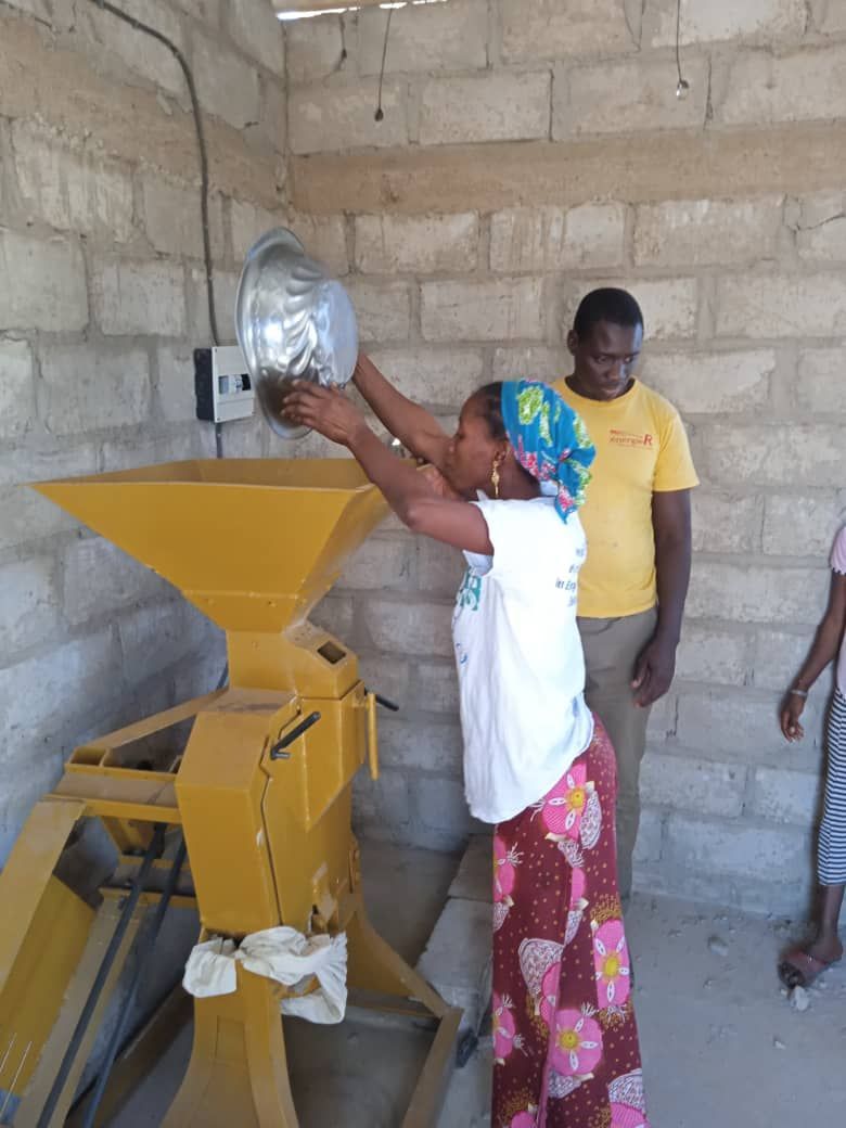 A woman is standing in front of a yellow machine