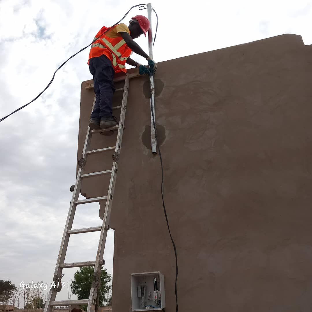 A man on a ladder working on a wall