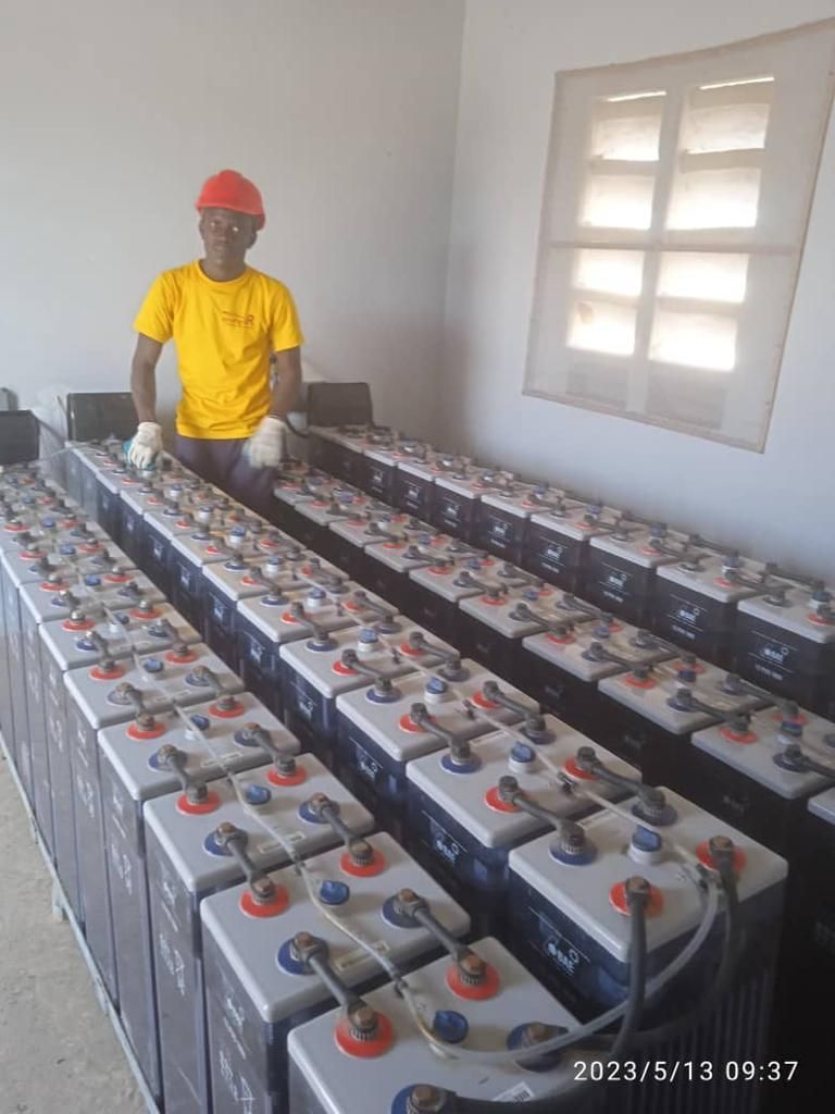 A man is standing in front of a row of batteries.