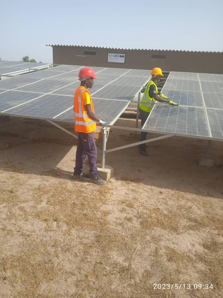 Two men are working on a solar panel.