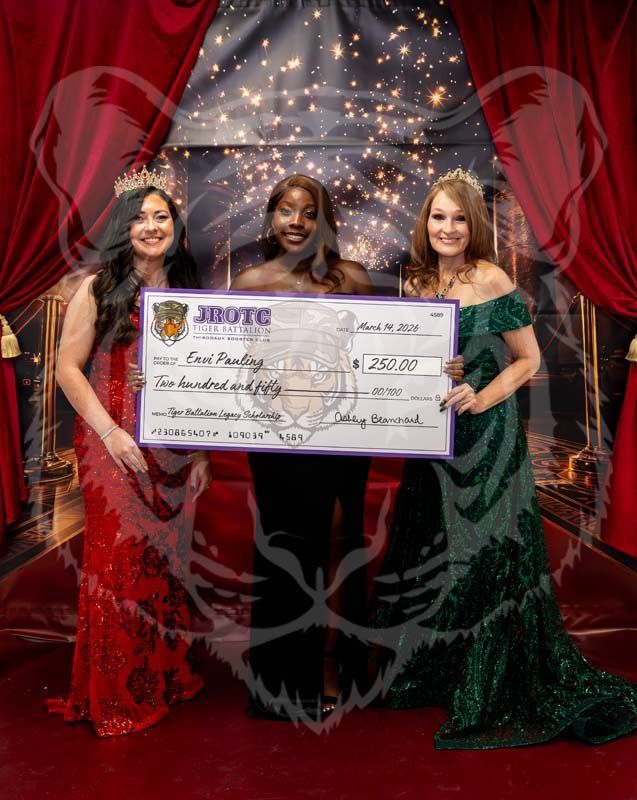 Three individuals in formal gowns hold a large check for $250.00 at an awards event in front of a red curtain backdrop.