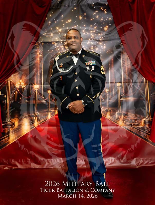 A person in a military dress uniform stands on a red carpet in front of draped curtains for the 2026 Military Ball.