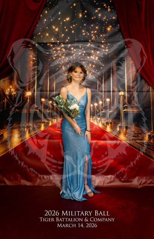 A person in a blue gown stands on a red carpet at the 2026 Military Ball, with a tiger graphic overlaid on the background.