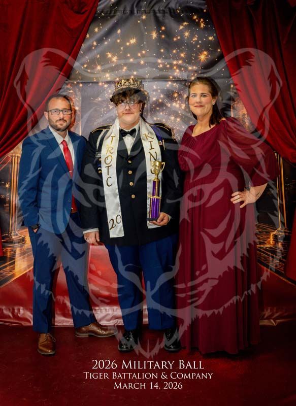 Three people pose formally at the 2026 Military Ball, with the center person wearing a crown and sash.