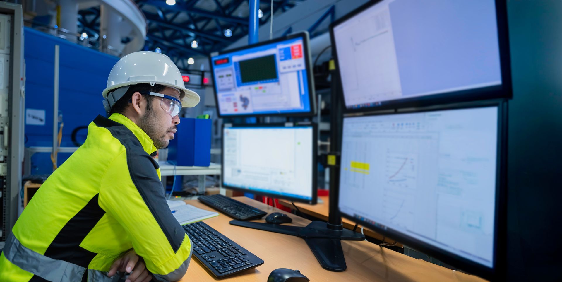 A man in a suit and tie is standing with his arms crossed in front of a warehouse.