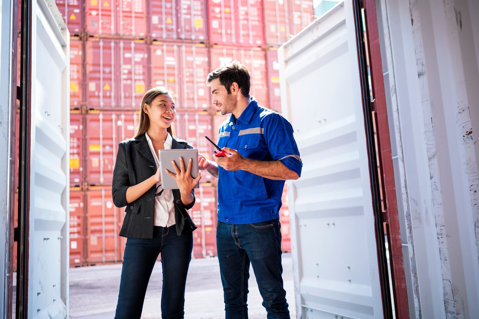 A man and a woman are standing next to each other in front of a container.