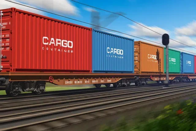 A train with cargo containers on it is going down the tracks.