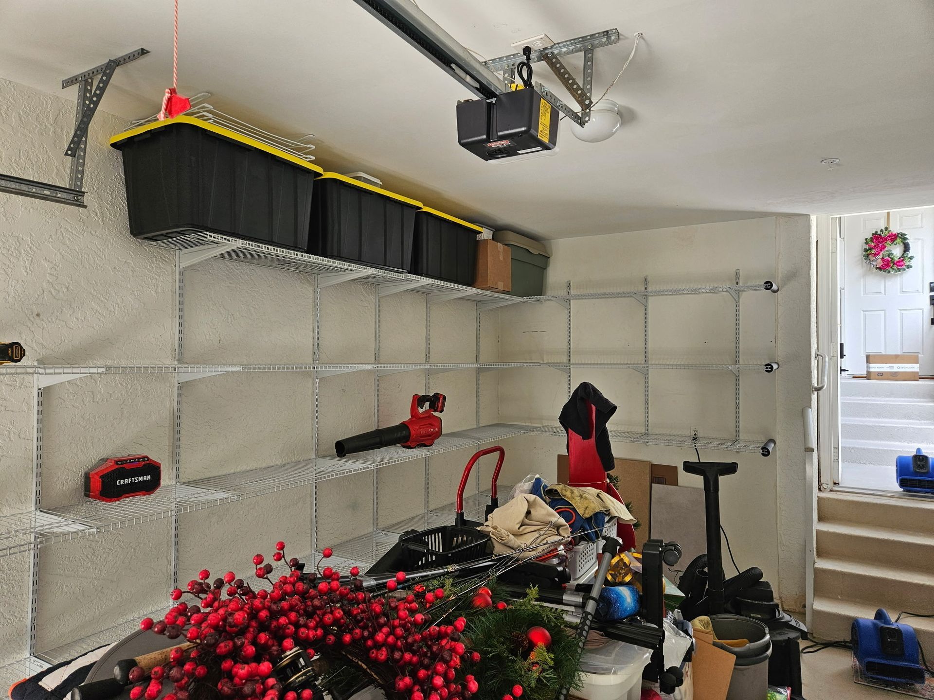 A garage interior with shelving units holding storage bins and items. 