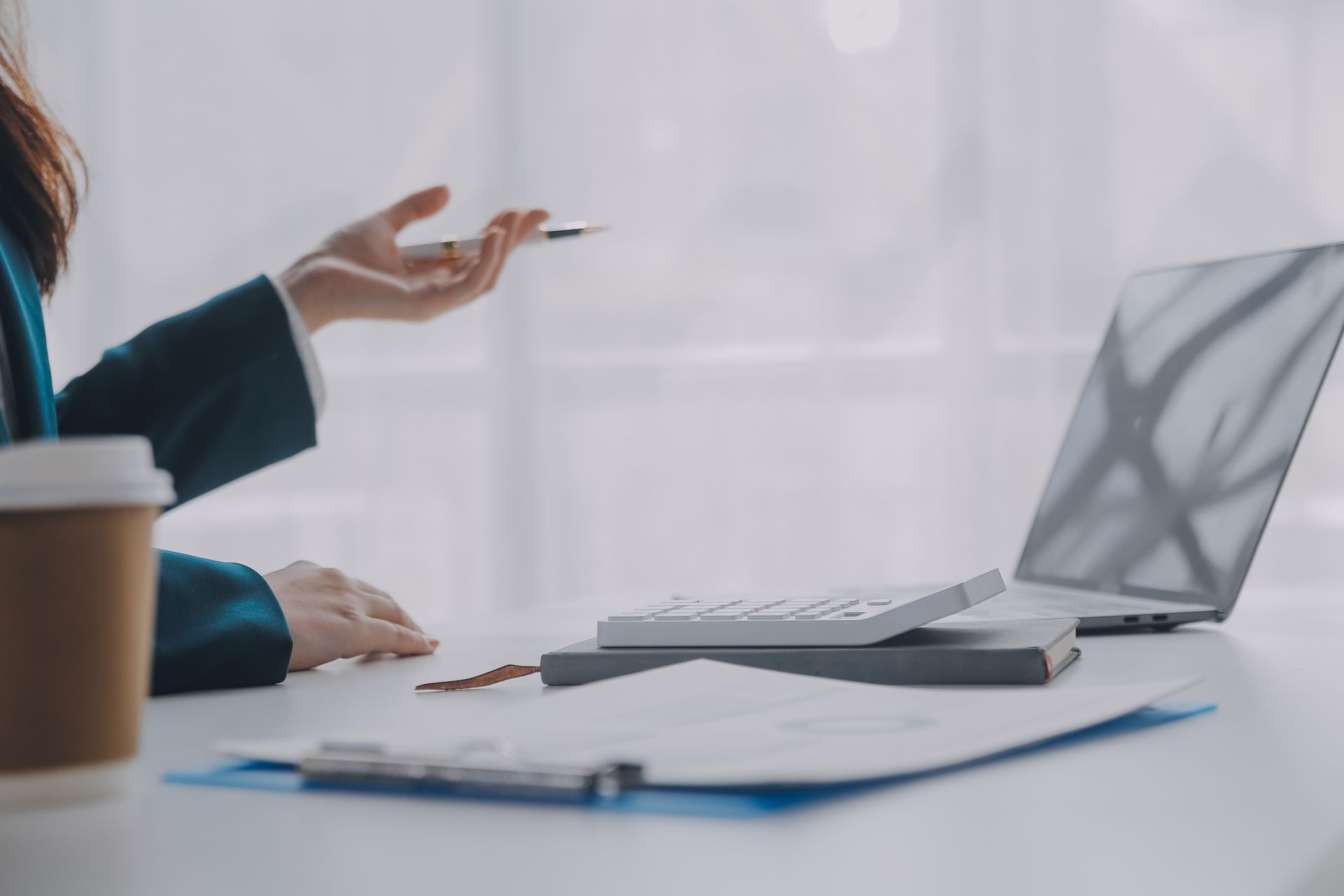 Woman in blue blazer points pen at laptop, representing business disputes in New York.