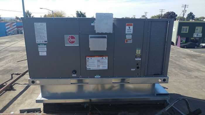 Black air ducts and pipes attached to a black ceiling.