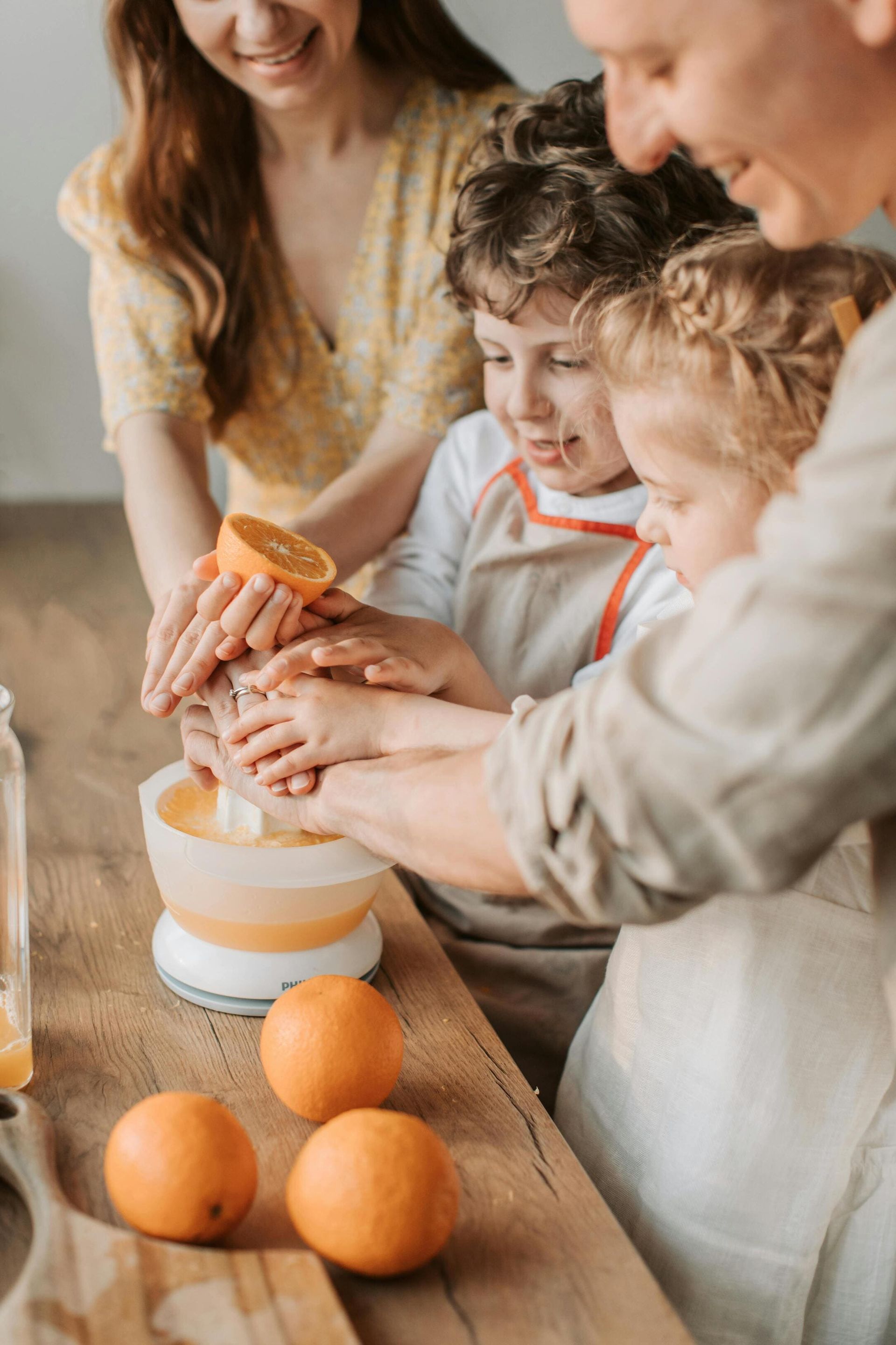 Parents teaching kids how to make healthy orange juice