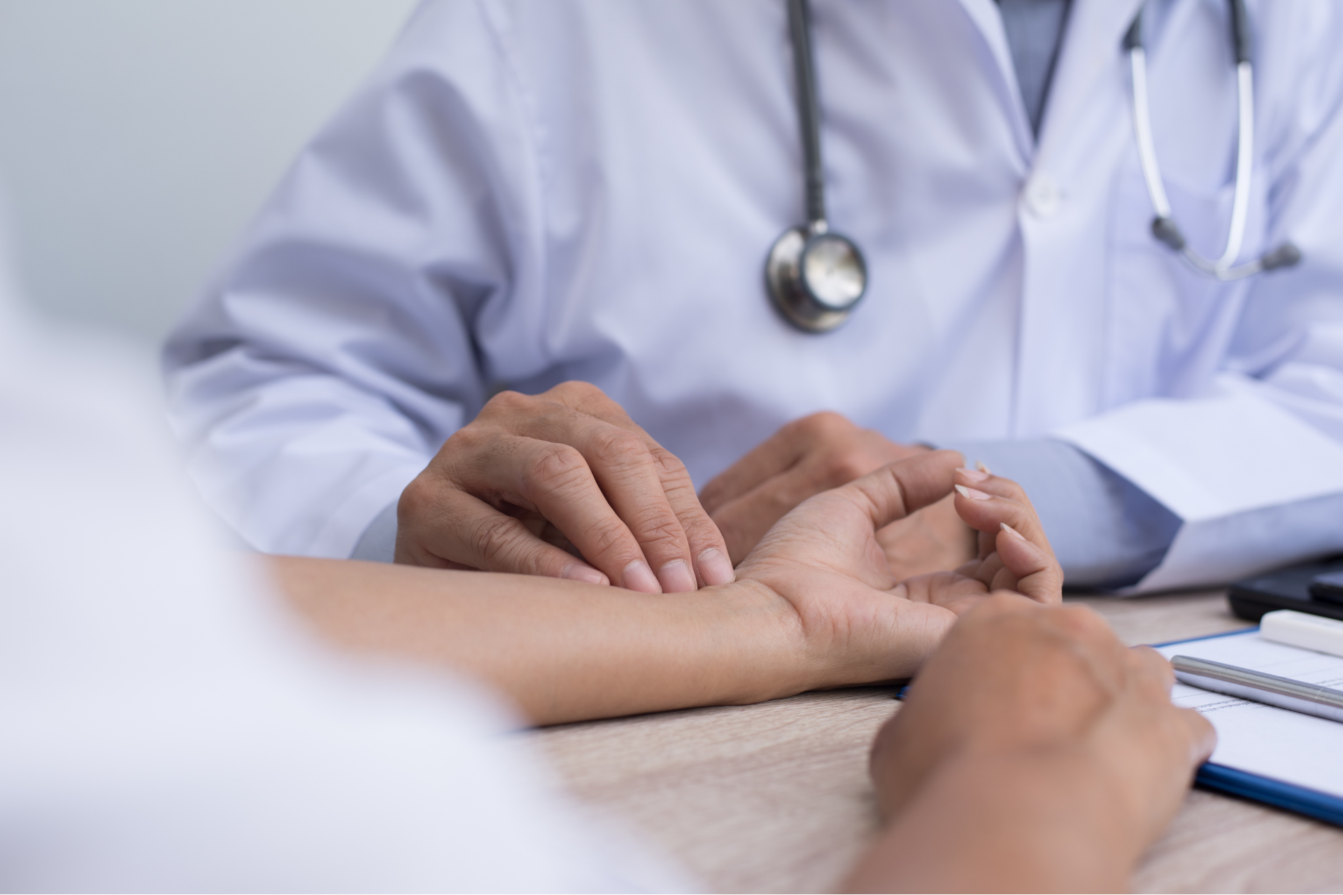 A doctor is taking a patient 's pulse during a physical exam