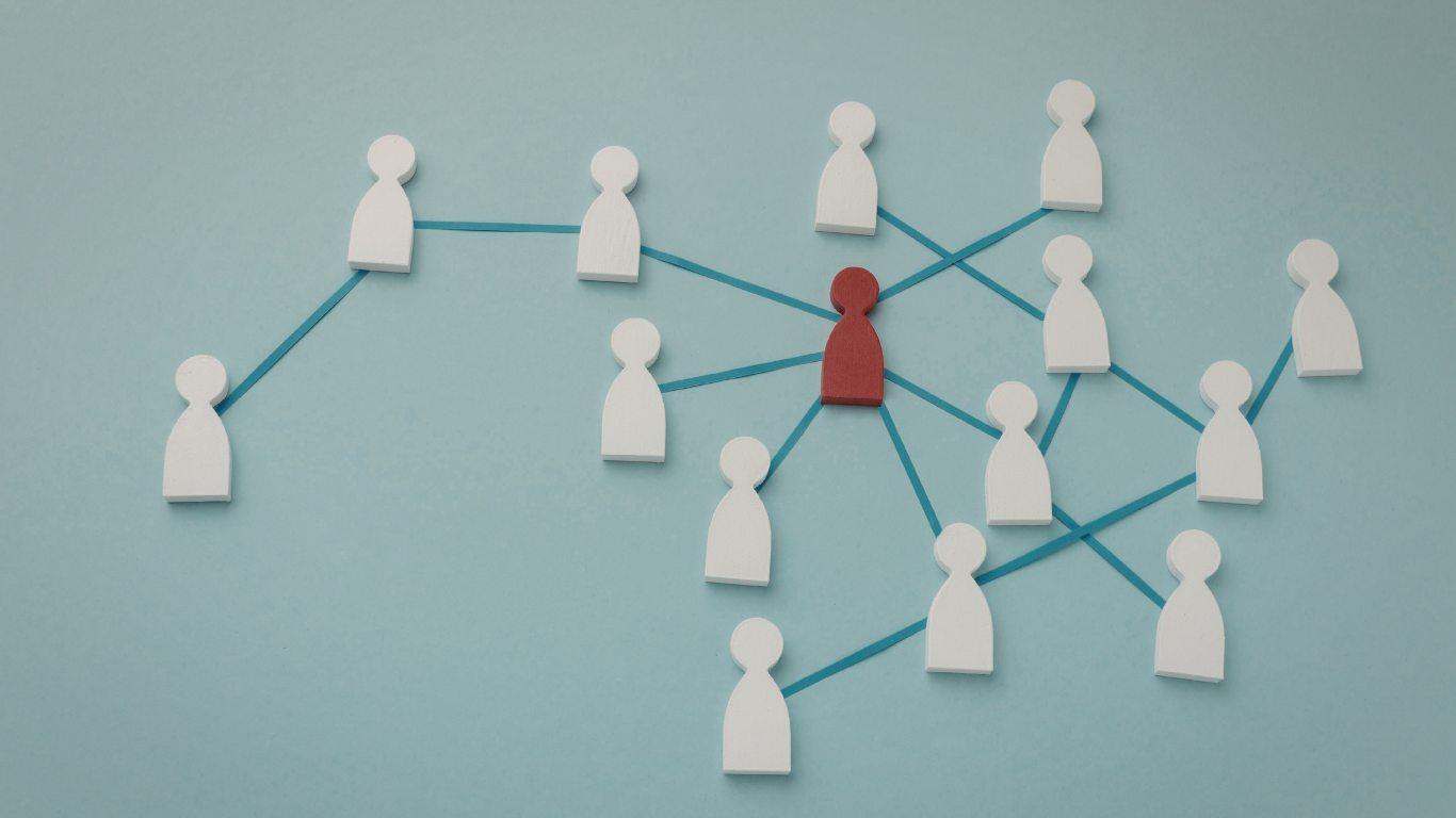 A central red figure connected by lines to many white figures on a light blue background, representing a network.