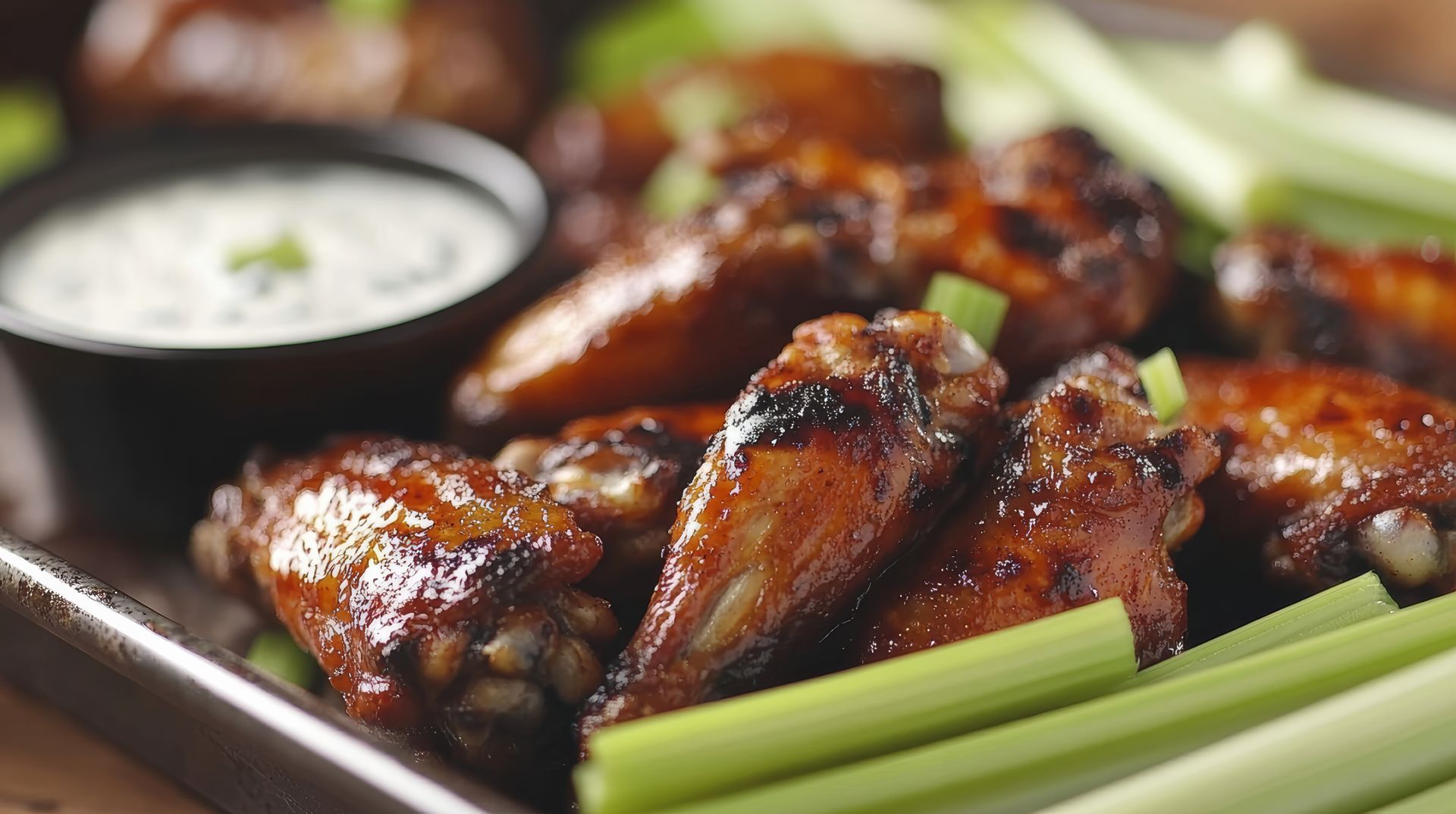 A close up of a plate of food with a glass of wine in the background.