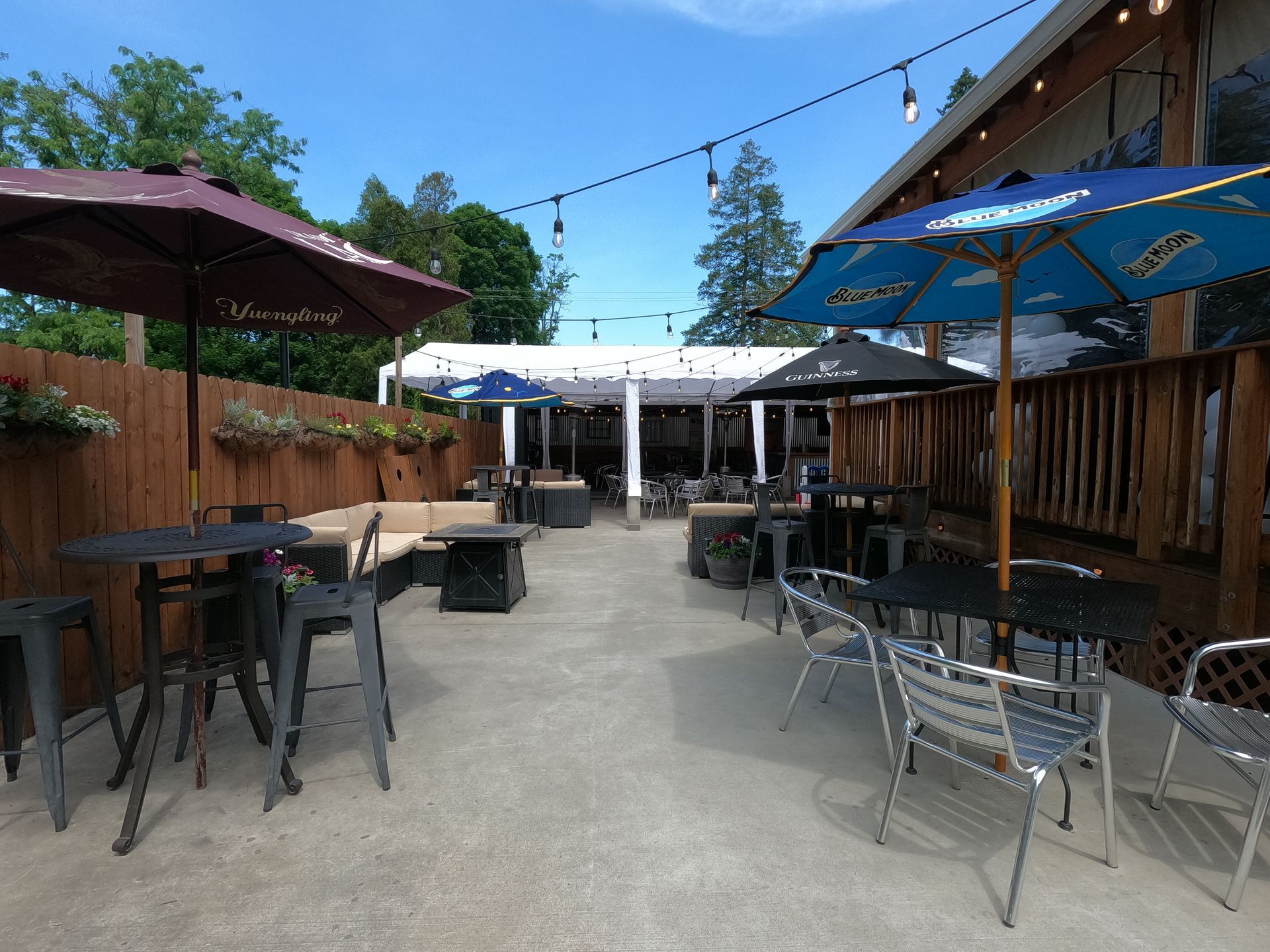 A patio with tables and chairs and umbrellas on a sunny day.
