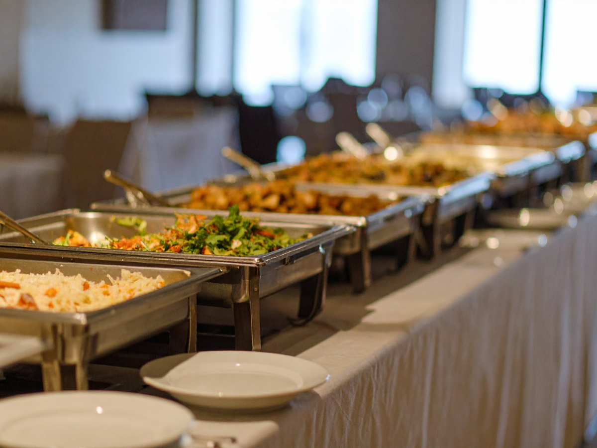 A close up of a plate of food with a glass of wine in the background.