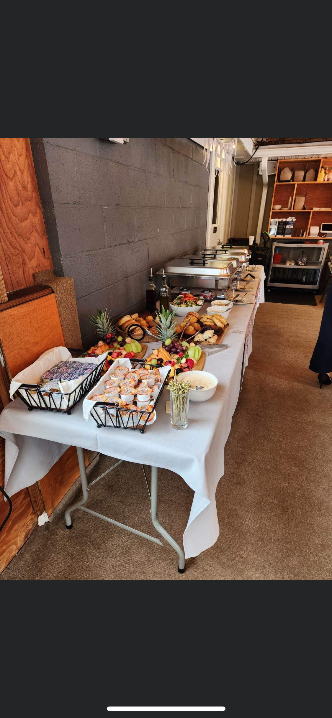 There is a long table with a lot of food on it at Happy Hour Bar & Grill.