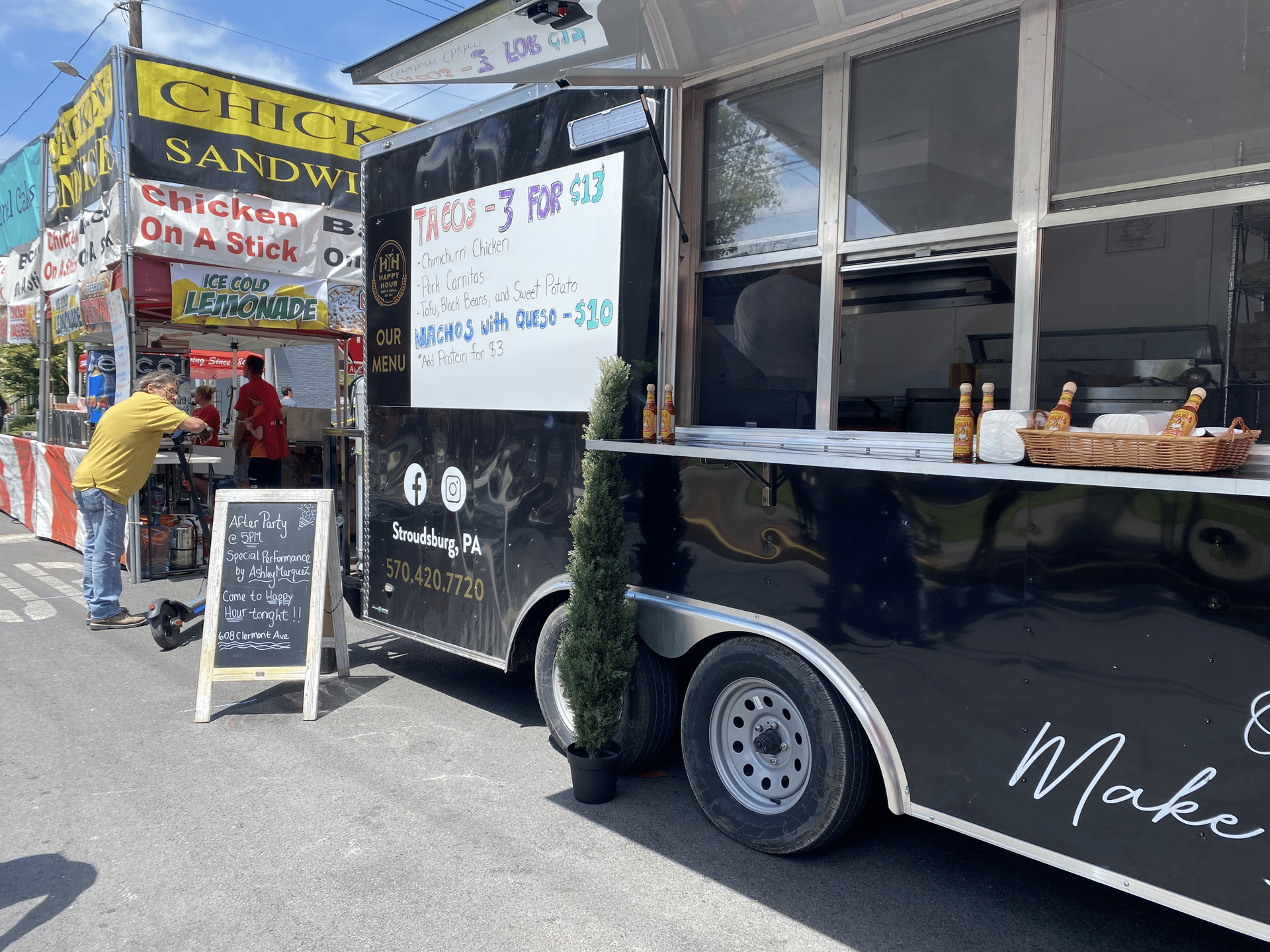 Happy Hour Bar & Grill food truck is parked at a festival