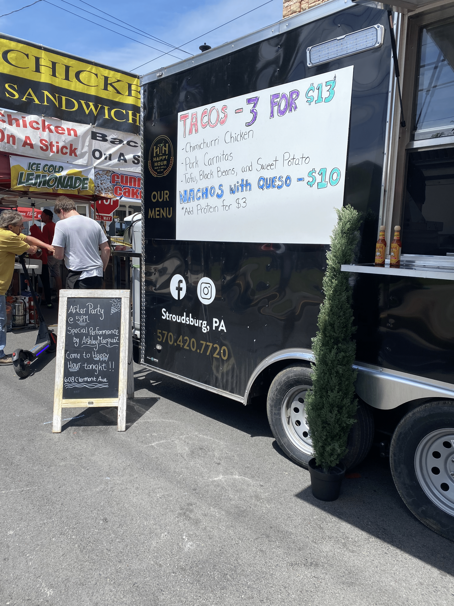 Happy Hour Bar & Grill food truck with a sign at a festival