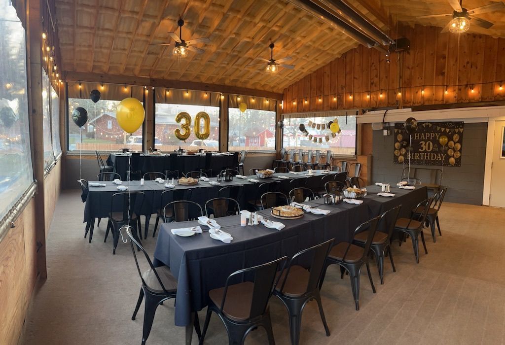 A large room with tables and chairs set up for a 30th birthday party at Happy Hour Bar & Grill