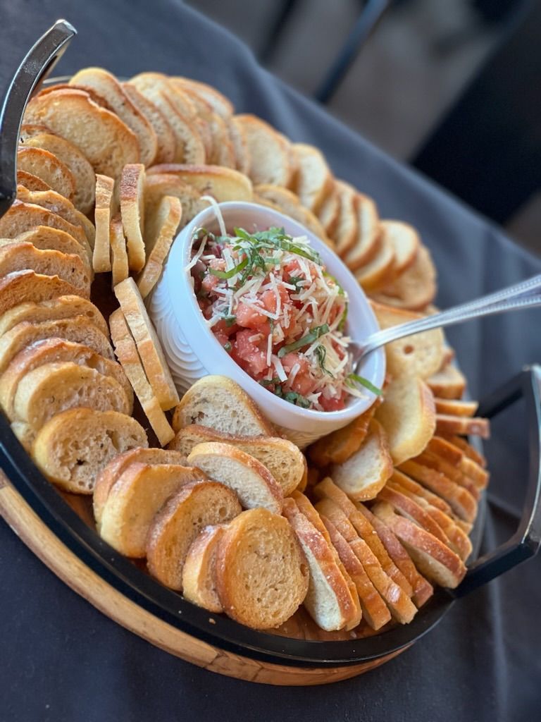 A tray of bagel chips and a bowl of dip on a table.